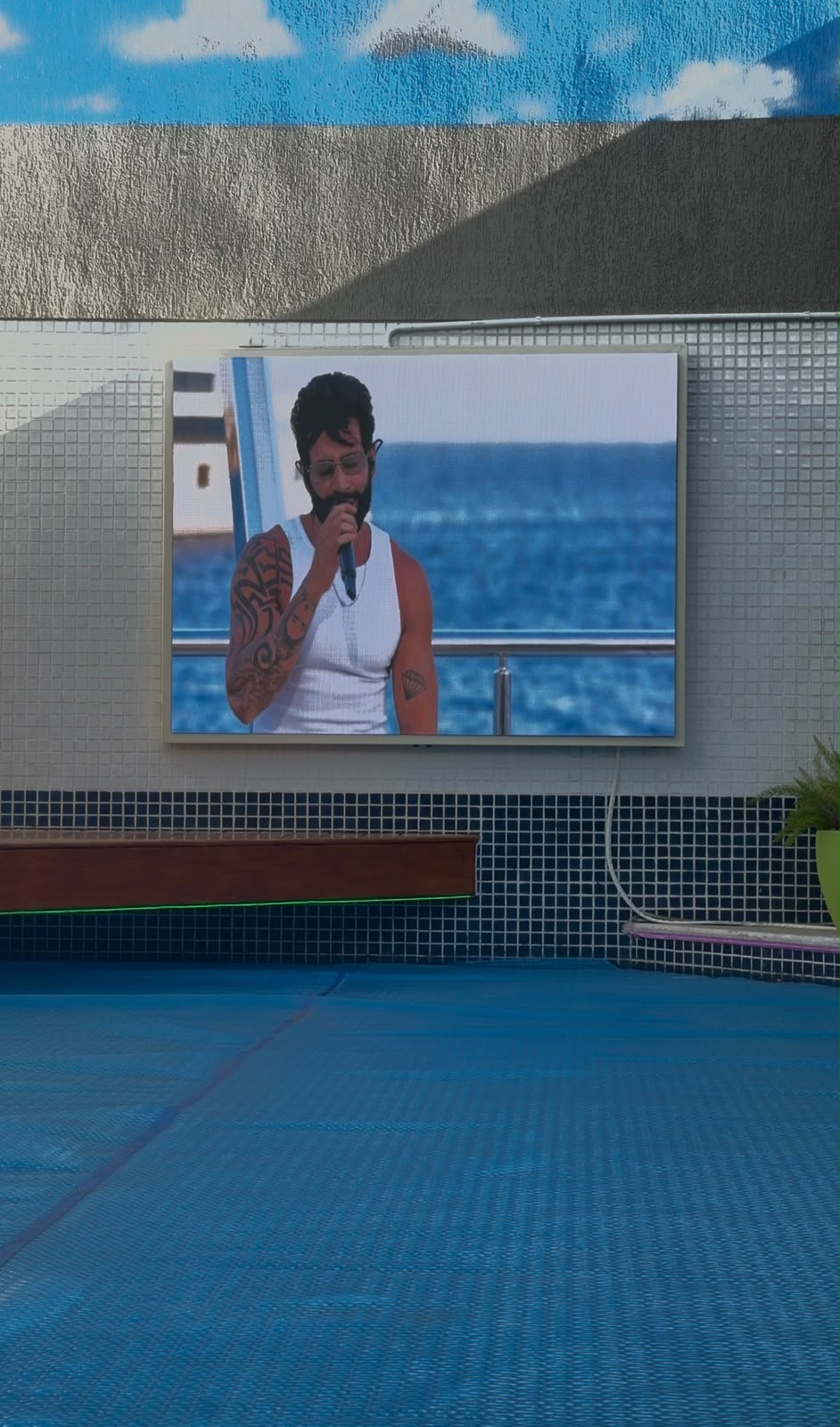 Painel de LED em área de piscina com vista para o mar