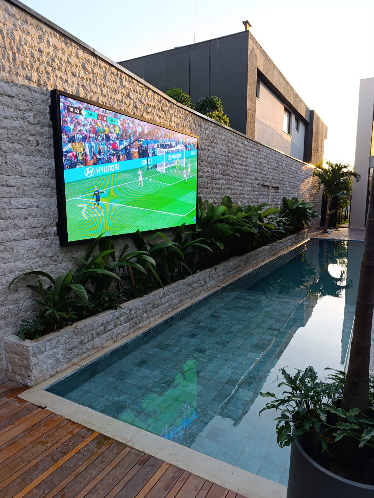 Painel de LED em fachada de pedra com futebol
